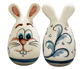 Uovo di Pasqua a forma di coniglio in ceramica artigianale con decoro floreale blu sul retro, fatto a mano a Bronte.