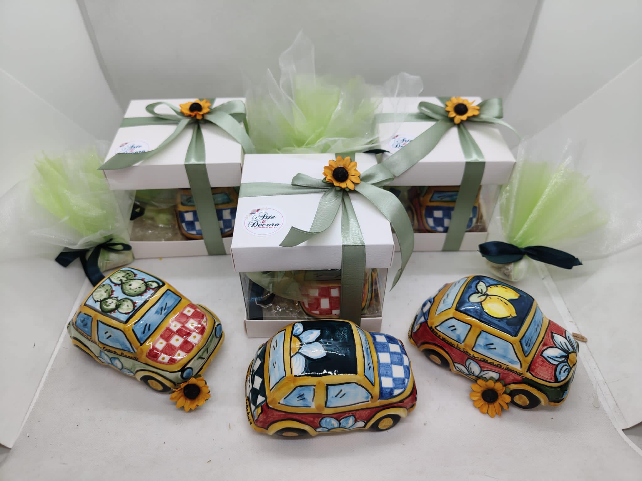Miniatura in ceramica di Fiat 500 decorata a mano con motivi tipici del carretto siciliano, colori giallo, rosso e blu cobalto. Bomboniera d'autore realizzata a Bronte da Arte&Decoro.