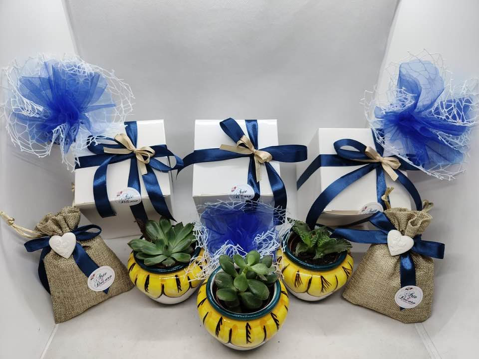 Assortimento di mini vasi portapiantina in ceramica siciliana decorati a mano con motivi di limoni, arance e trame geometriche blu. Bomboniere d'autore realizzate a Bronte da Arte&Decoro.
